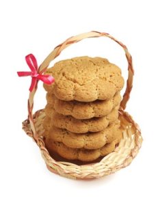 Oatmeal cookies in wicker basket on a white background